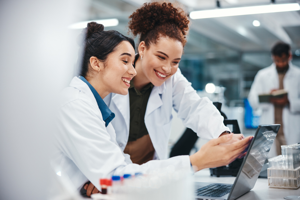 Twee apothekers overleggen samen achter een laptop