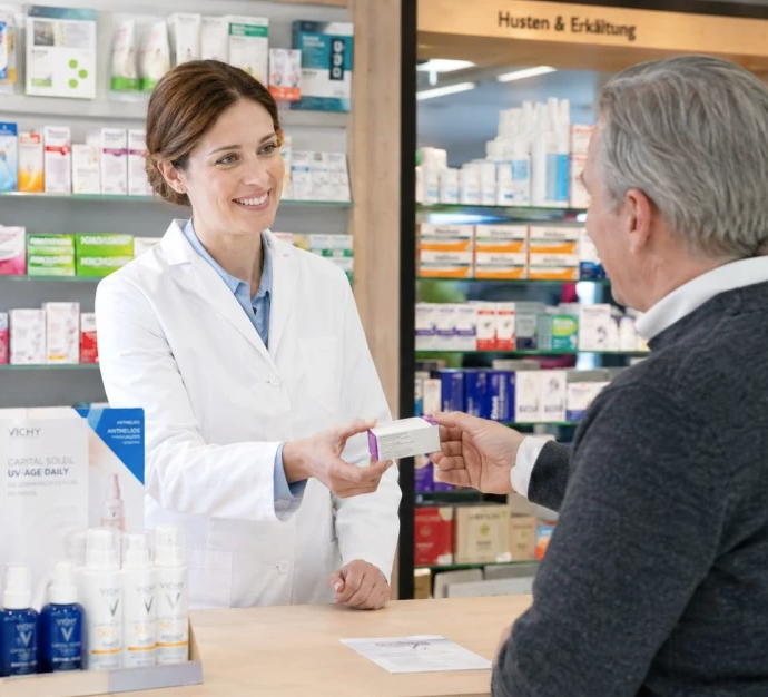 Patiënt in gesprek met de apotheker aan de toonbank
